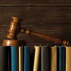 Gavel With Books On Old Wooden Desk